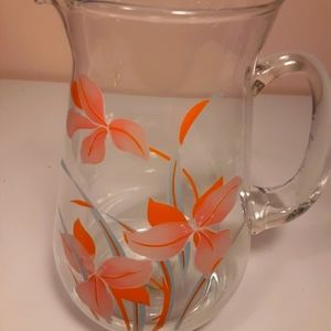 Clear glass pitcher with orange lily flowers